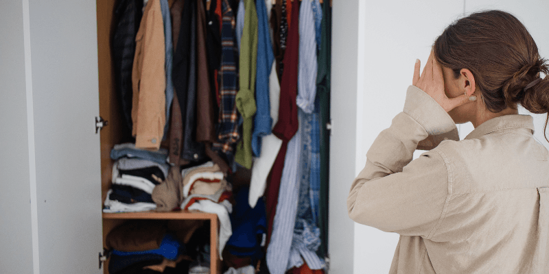 Frustrated Woman Looking at Cluttered Built In Wardrobe