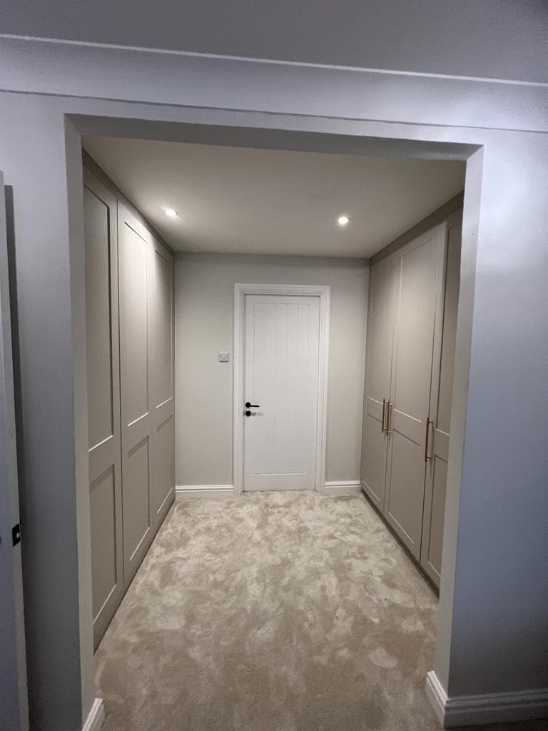 U-shaped walk-in wardrobe layout with rails, drawers and open shelving.