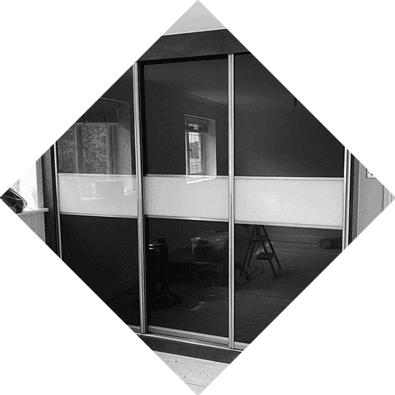 Built-in sliding glass wardrobe with reflective panels, perfect for modern homes or showroom spaces.
