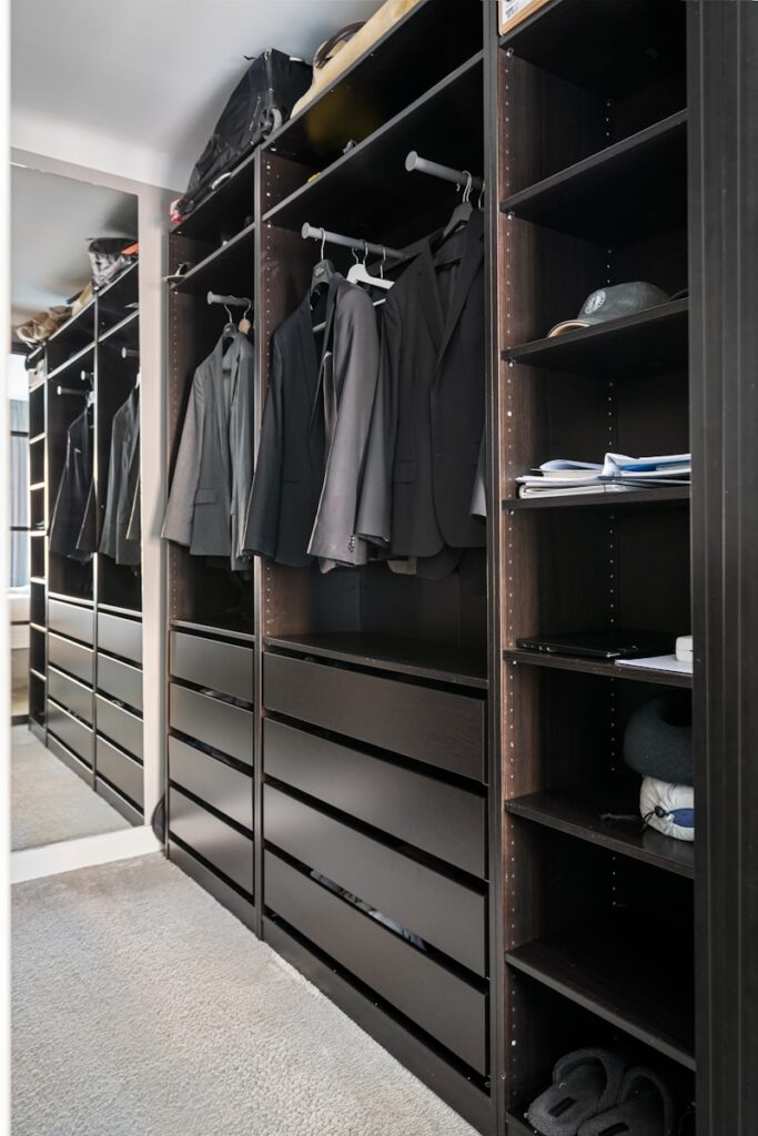 A walk in closet filled with lots of clothes