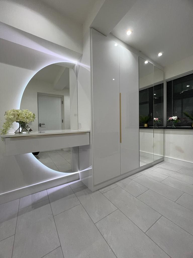 White gloss mirrored fitted wardrobe furniture with opening doors and built-in dressing table and mirror