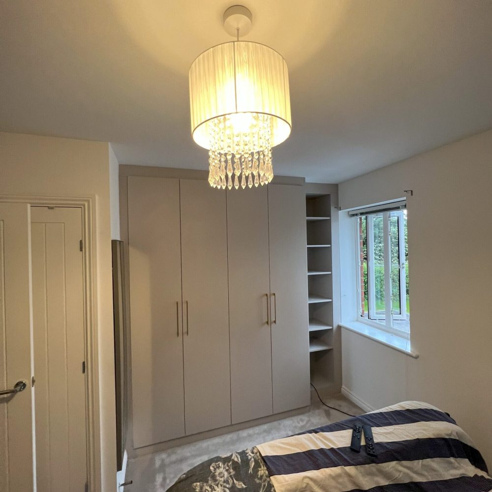 Custom hinged fitted wardrobe furniture with classic handles and a warm room setting