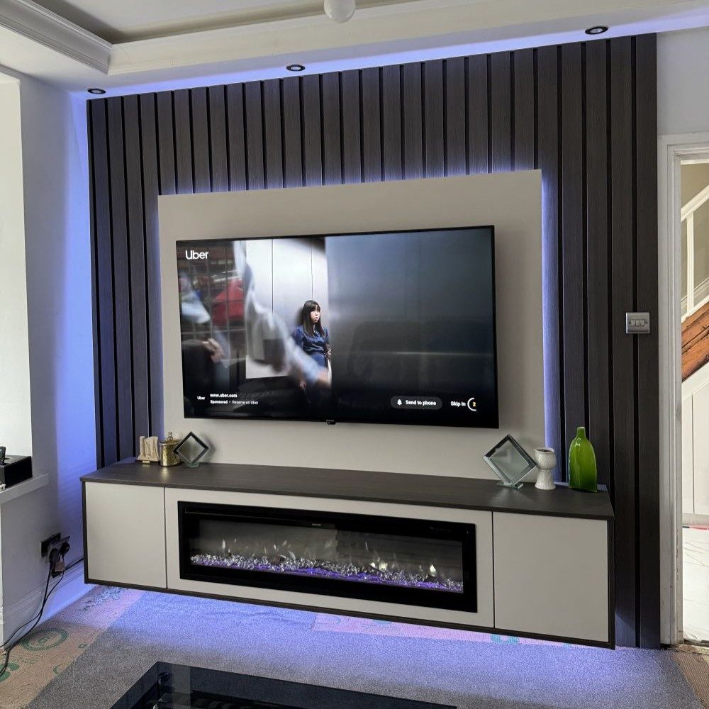 Custom TV unit with integrated shelves and drawers built into living room wall.