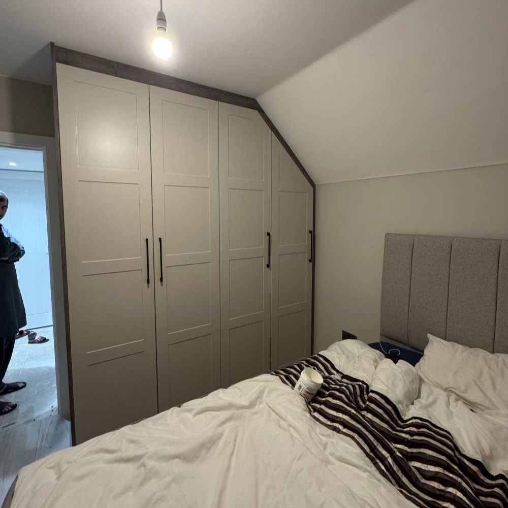 Custom full-height fitted wardrobe with shaker-style white doors for ample storage space.