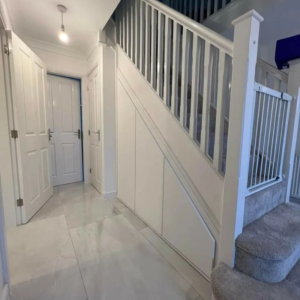 Tailor-made drawers and cabinets built beneath stairs for efficient storage use.